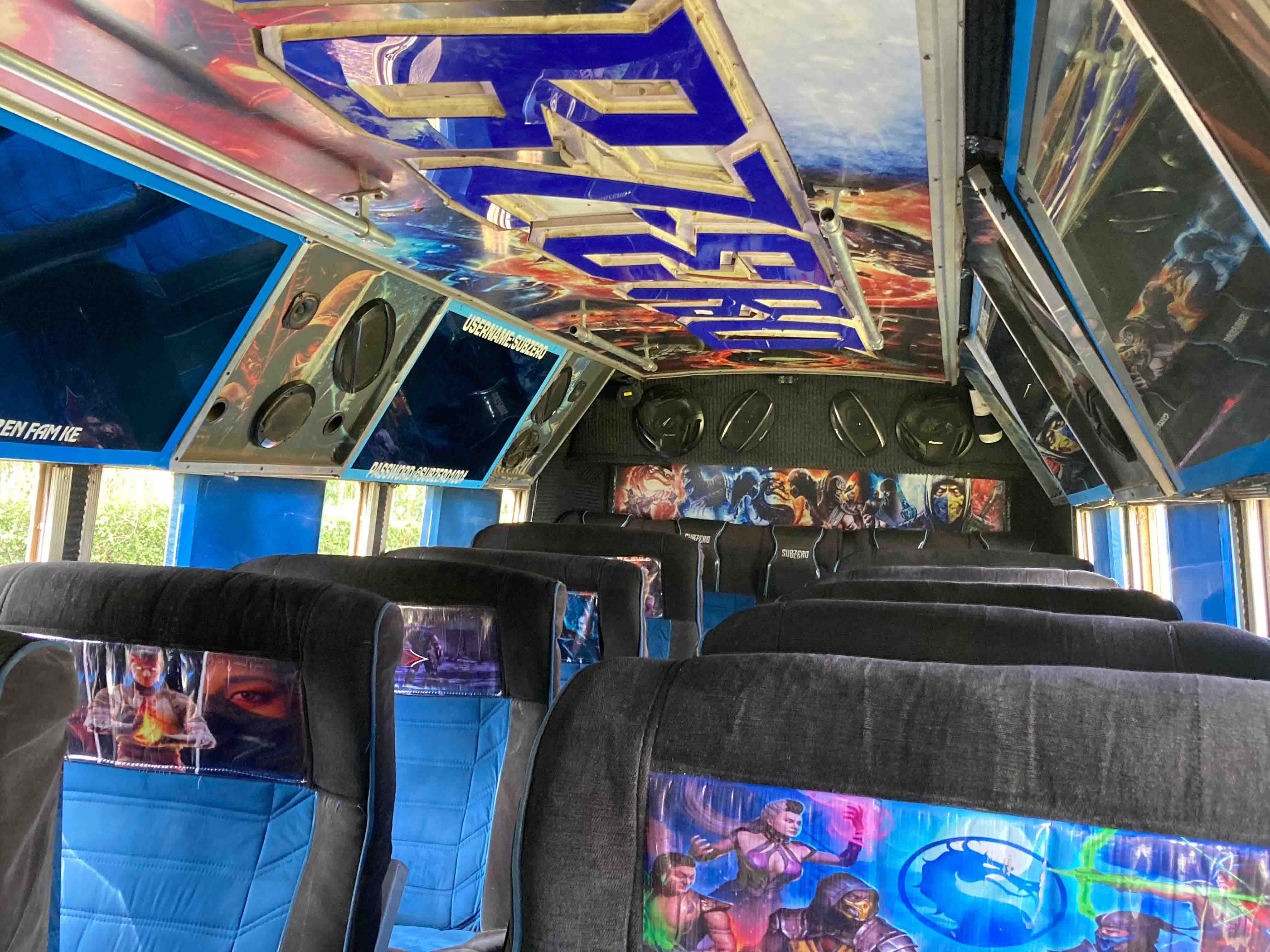 The interior of a Kenyan matatu (minibus) with brightly colored seats, graffiti-style designs on the seat covers, and customized ceiling decor featuring speakers and neon lighting.