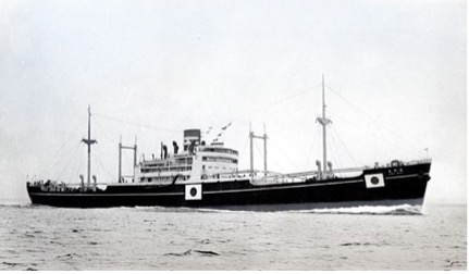 A black-and-white photograph of a Minamimaru sailing on calm waters, featuring a superstructure and masts equipped with cargo handling cranes.